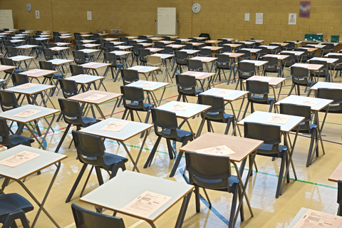 Examination hall with desks and exam papers showing the importance of exam technique